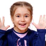 A happy and excited Caucasian girl with palms raised up