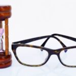 Spectacles beside an hourglass indicating time is running out